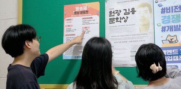 다가오는 신문방송사 행사인 방송제와 김용 문학상의 포스터를 보고 있는 학생들 / 사진 : 조혜연 기자   